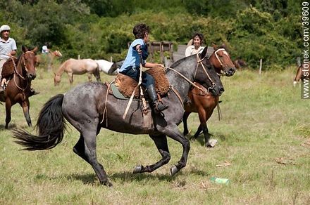 Jóvenes jinetes cabalgando en el campo - Departamento de Tacuarembó - URUGUAY. Foto No. 39609