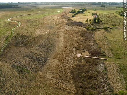 Vista aérea de apenas un hilo de agua del arroyo Canelón Grande durante la sequía del año 2023. Se aprecian los muelles de hasta dónde llega el agua normalmente - Departamento de Canelones - URUGUAY. Foto No. 82030