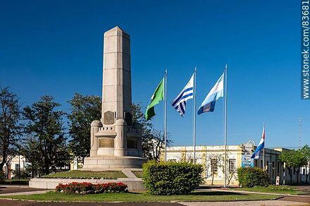 Obelisk and local and international flags in the Batlle y Ordóñez square. - Artigas - URUGUAY. Photo #83681
