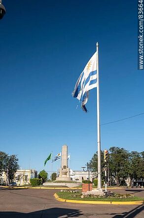 Obelisco y banderas locales e internacionales en la plaza Batlle y Ordóñez - Departamento de Artigas - URUGUAY. Foto No. 83664