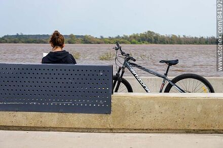 Cyclist reading a book in front of the Uruguay river - Department of Paysandú - URUGUAY. Photo #84192