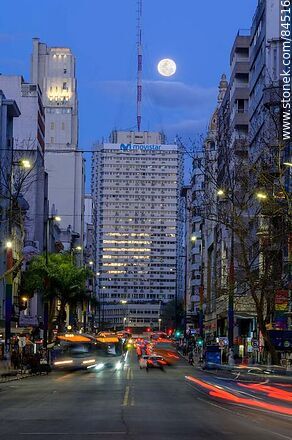 18 de Julio Avenue. Gaucho Tower. Trail of lights left by the traffic at dusk. The full moon - Department of Montevideo - URUGUAY. Photo #84516