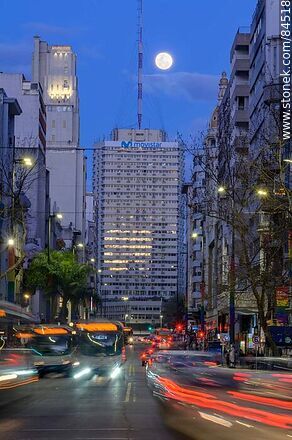 18 de Julio Avenue. Gaucho Tower. Trail of lights left by the traffic at dusk. The full moon - Department of Montevideo - URUGUAY. Photo #84518