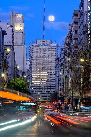 18 de Julio Avenue. Gaucho Tower. Trail of lights left by the traffic at dusk. The full moon - Department of Montevideo - URUGUAY. Photo #84519