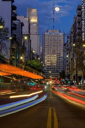 18 de Julio Avenue. Gaucho Tower. Trail of lights left by the traffic at dusk. The full moon - Department of Montevideo - URUGUAY. Photo #84522