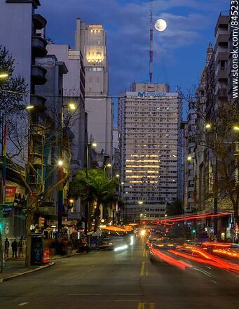 18 de Julio Avenue. Gaucho Tower. Trail of lights left by the traffic at dusk. The full moon - Department of Montevideo - URUGUAY. Photo #84523