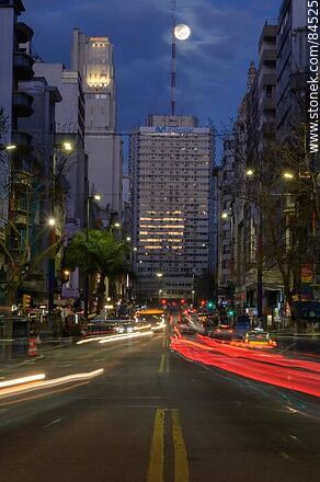 18 de Julio Avenue. Gaucho Tower. Trail of lights left by the traffic at dusk. The full moon - Department of Montevideo - URUGUAY. Photo #84525