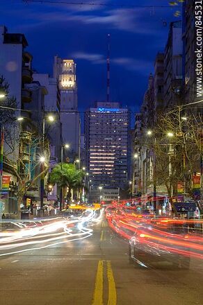 18 de Julio Avenue. Gaucho Tower. Trail of lights left by the traffic at dusk. The full moon - Department of Montevideo - URUGUAY. Photo #84531
