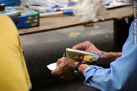Feria de Tristán Narvaja. Armando un cigarrillo. - Departamento de Montevideo - URUGUAY. Foto No. 31021