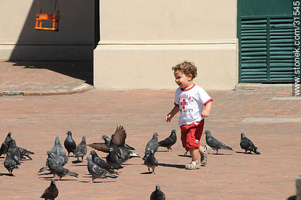 Niño divertido con las palomas - Departamento de Montevideo - URUGUAY. Foto No. 31545