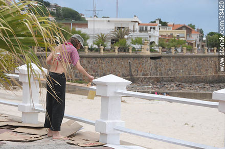 Joven pintando las barandas de la playa de Piriápolis previo a la inauguración de la temporada de verano - Departamento de Maldonado - URUGUAY. Foto No. 33420