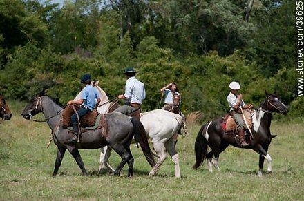 Jóvenes jinetes cabalgando en el campo - Departamento de Tacuarembó - URUGUAY. Foto No. 39625