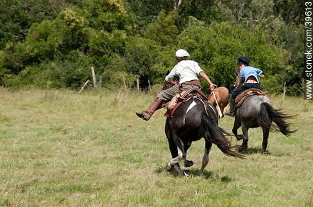 Jóvenes jinetes cabalgando en el campo - Departamento de Tacuarembó - URUGUAY. Foto No. 39613