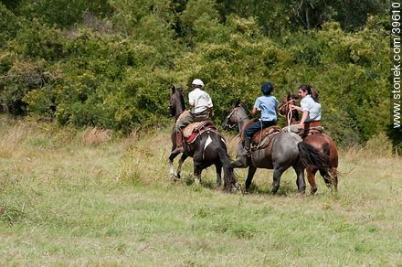 Jóvenes jinetes cabalgando en el campo - Departamento de Tacuarembó - URUGUAY. Foto No. 39610