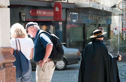 Turistas de espaldas al Zorro en la peatonal Sarandí - Departamento de Montevideo - URUGUAY. Foto No. 40837