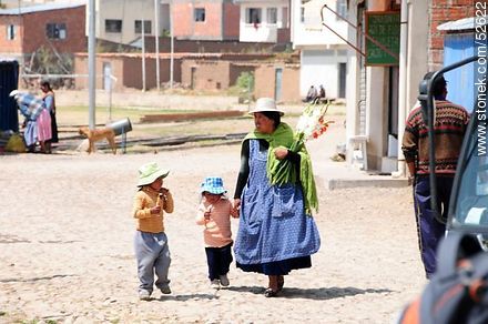 Tiquina. Chola boliviana con un ramo de gladiolos y sus hijos disfrutando de una golosina - Bolivia - Otros AMÉRICA del SUR. Foto No. 52622