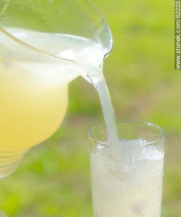 Lemonade with ice in a glass jar being served in a glass -  - MORE IMAGES. Photo #62223