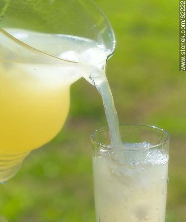 Lemonade with ice in a glass jar being served in a glass -  - MORE IMAGES. Photo #62222