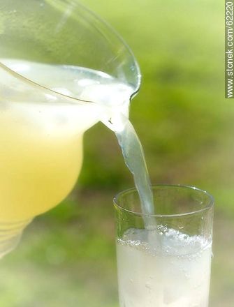 Lemonade with ice in a glass jar being served in a glass -  - MORE IMAGES. Photo #62220