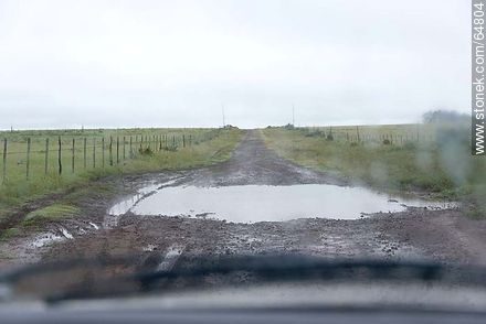 Hole filled with water in the middle of a road in the countryside - Department of Salto - URUGUAY. Foto No. 64804