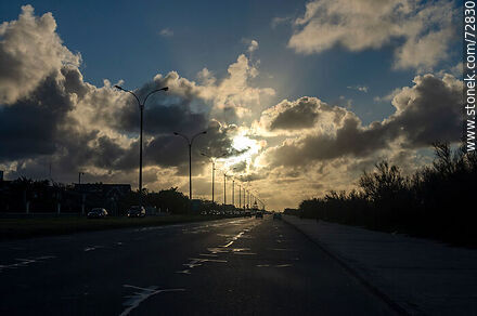 El sol entre las nubes en un amanecer invernal en la rambla - Departamento de Montevideo - URUGUAY. Foto No. 72830