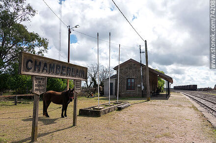 Horse grazing under one of the station signs - Tacuarembo - URUGUAY. Photo #74208