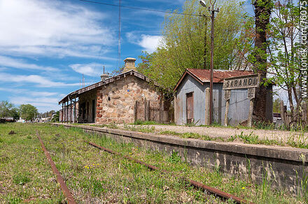 Estación de ferrocarril de Sarandí Grande. Vias oxidadas que asoman en el pasto frente al andén - Departamento de Florida - URUGUAY. Foto No. 76075