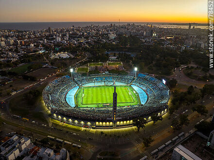 Aerial view of the Centenario Stadium illuminated at sunset with a view of the city. - Department of Montevideo - URUGUAY. Photo #78452