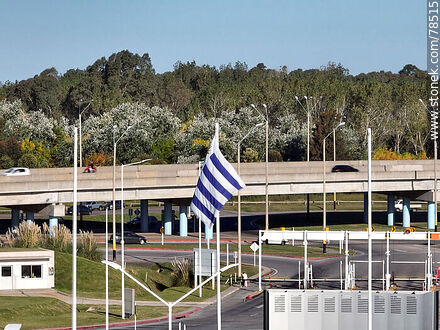 Vista aérea de la bandera uruguaya con fondo el acceso elevado de las rutas 101 e Interbalnearia - Departamento de Canelones - URUGUAY. Foto No. 78515