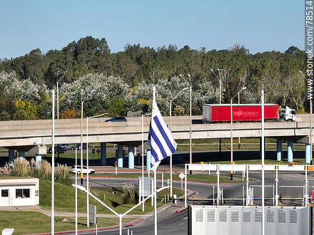 Vista aérea de la bandera uruguaya con fondo el acceso elevado de las rutas 101 e Interbalnearia - Departamento de Canelones - URUGUAY. Foto No. 78514
