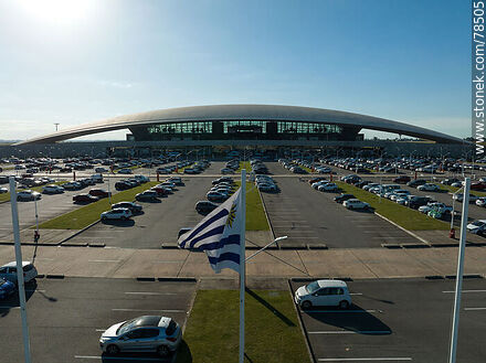 Vista aérea de la bandera uruguaya flameando frente al estacionamiento del aeropuerto - Departamento de Canelones - URUGUAY. Foto No. 78505