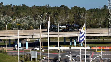 Vista aérea de la bandera uruguaya con fondo el acceso elevado de las rutas 101 e Interbalnearia - Departamento de Canelones - URUGUAY. Foto No. 78511