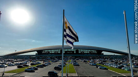 Vista aérea de la bandera uruguaya flameando frente al estacionamiento del aeropuerto - Departamento de Canelones - URUGUAY. Foto No. 78504