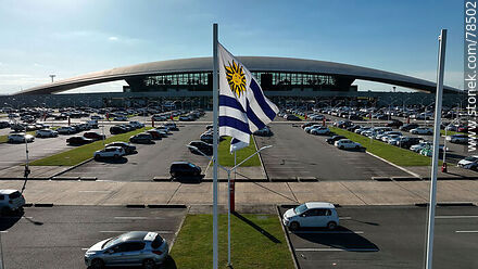 Vista aérea de la bandera uruguaya flameando frente al estacionamiento del aeropuerto - Departamento de Canelones - URUGUAY. Foto No. 78502