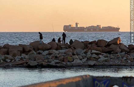 Fishermen on a breakwater in Punta Carretas and a cargo ship entering the port - Department of Montevideo - URUGUAY. Photo #79044