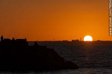 Silhouette of fishermen with the sun disappearing below the horizon - Department of Montevideo - URUGUAY. Photo #79054