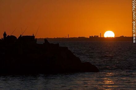 Silhouette of fishermen with the sun disappearing below the horizon - Department of Montevideo - URUGUAY. Photo #79055