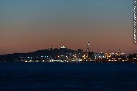 The port and the Cerro with its fortress illuminated at sunset - Department of Montevideo - URUGUAY. Photo #79092