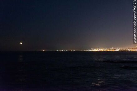 La luna nueva próxima a ocultarse en el mar frente al puerto de Montevideo. Un avión le hace compañia - Departamento de Montevideo - URUGUAY. Foto No. 79078
