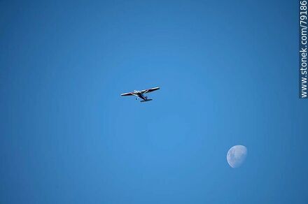 Light aircraft accompanying the moon in the sky -  - MORE IMAGES. Photo #79186