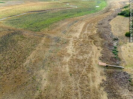 Vista aérea de apenas un hilo de agua del arroyo Canelón Grande durante la sequía del año 2023. Se aprecian los muelles de hasta dónde llega el agua normalmente - Departamento de Canelones - URUGUAY. Foto No. 82032
