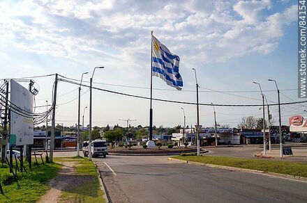 Bandera uruguaya flameando en el cruce de las avenidas Artigas, Salto y Ferreira Aldunate - Departamento de Paysandú - URUGUAY. Foto No. 84154