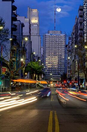 18 de Julio Avenue. Gaucho Tower. Trail of lights left by the traffic at dusk. The full moon - Department of Montevideo - URUGUAY. Photo #84521