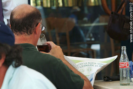 A man reading the newspaper drinking a Coke - Punta del Este and its near resorts - URUGUAY. Photo #8012