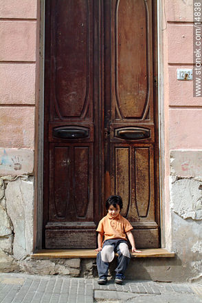 Niño frente a puerta antigua - Departamento de Montevideo - URUGUAY. Foto No. 14838