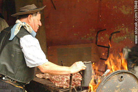 Gaucho preparando un asado - Departamento de Montevideo - URUGUAY. Foto No. 13848