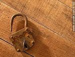 Viejo candado oxidado con llave, sobre una tabla. - Foto #8762
